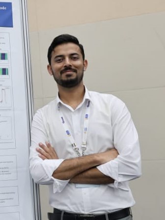 Muhammad Mustafa Khan standing beside his research poster at the IFAC World Congress in Busan.
