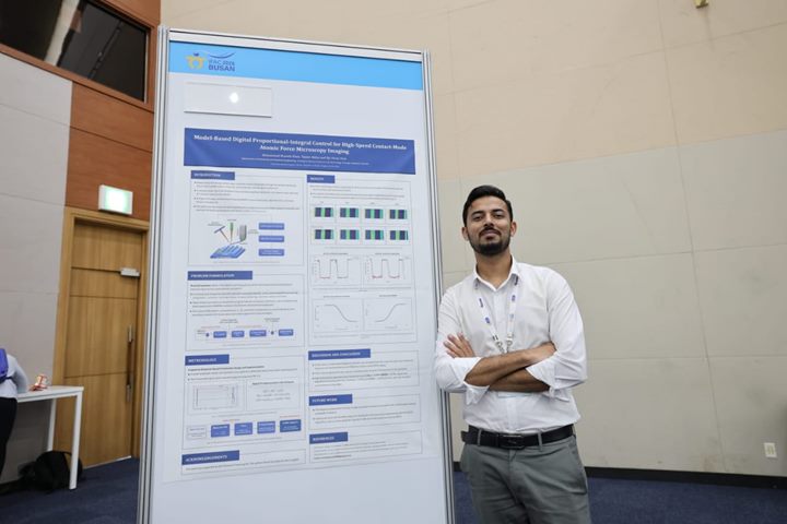 Muhammad Mustafa Khan beside the AFM control poster at the IFAC World Congress in Busan.